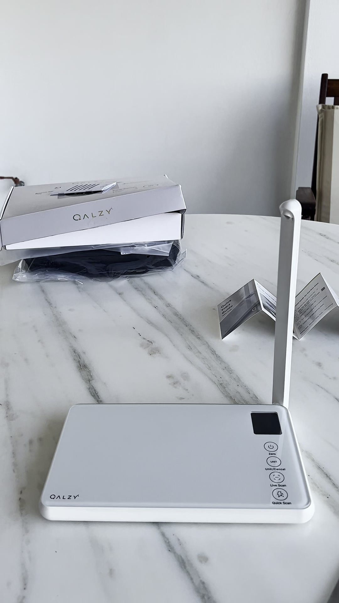 Customer photo of the scale, box, and manual on a table